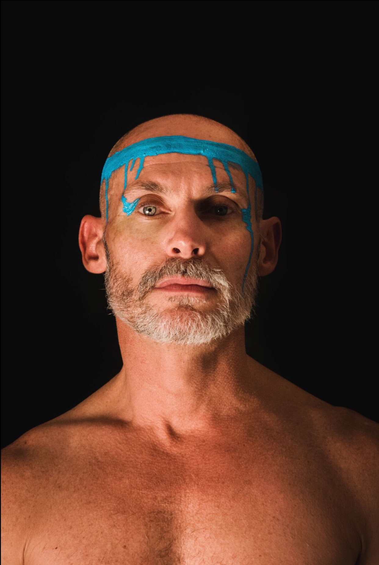 Magnus portrait promo – Magnus Dean Image of Magnus with blue face paint on black background